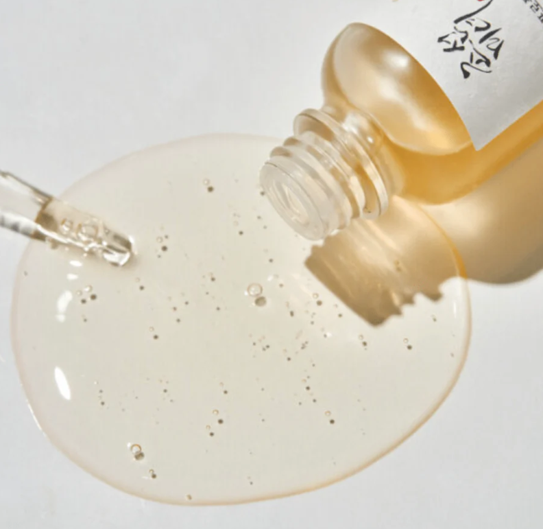 Close-up of a dropper bottle with beige liquid on a white background