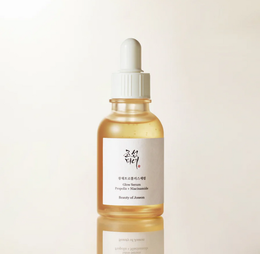 Skincare serum bottle with dropper on a light beige background