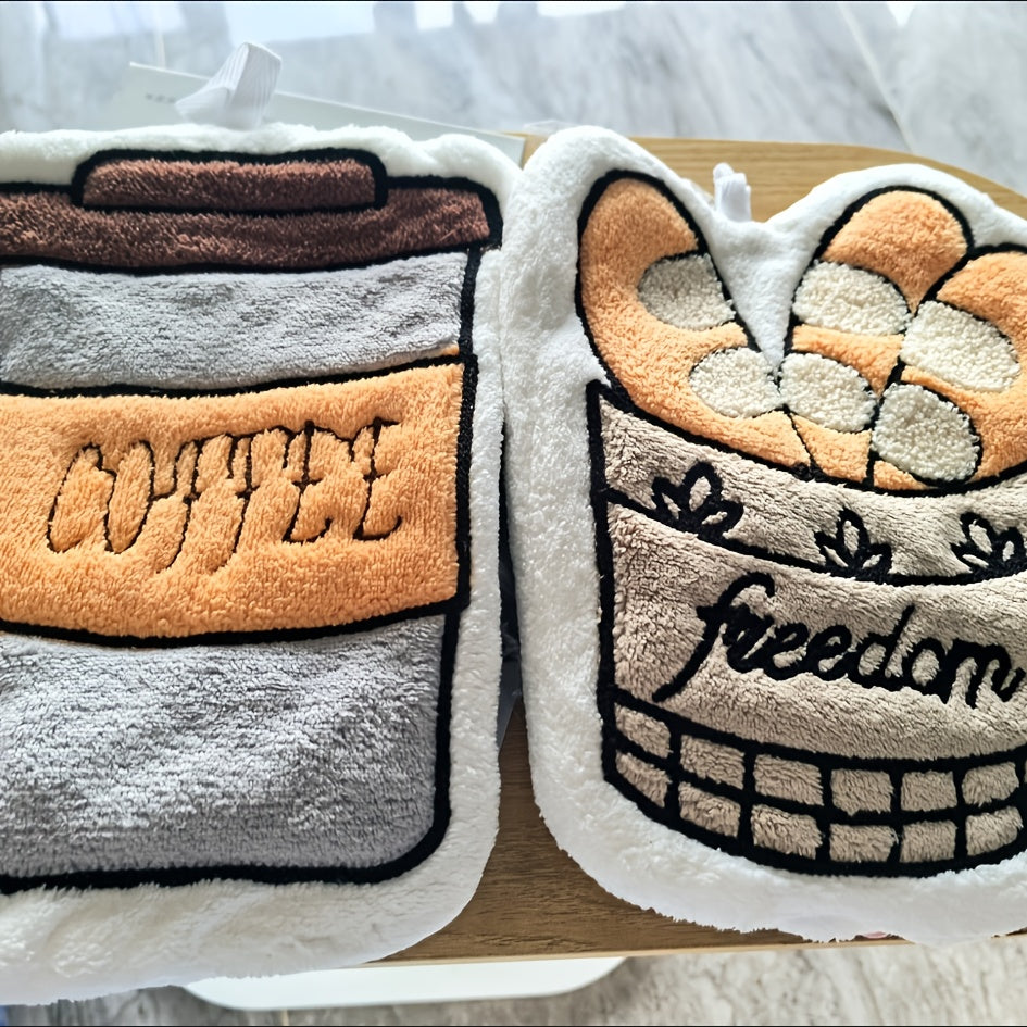 Two plush toys shaped like coffee cups and a heart with 'freedom' text on a wooden surface.