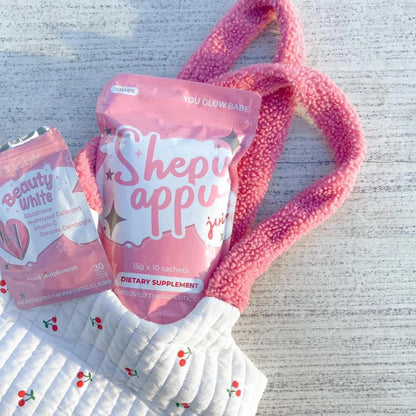 You Glow Babe Shepu appu juice in a pink packaging and a bag with Beauty white capsules packs in white grey backgroung