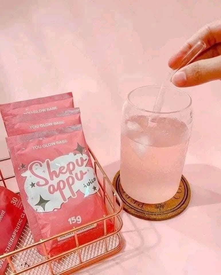 You glow babe sachets in a tray and a glass of juice with straw in pink background