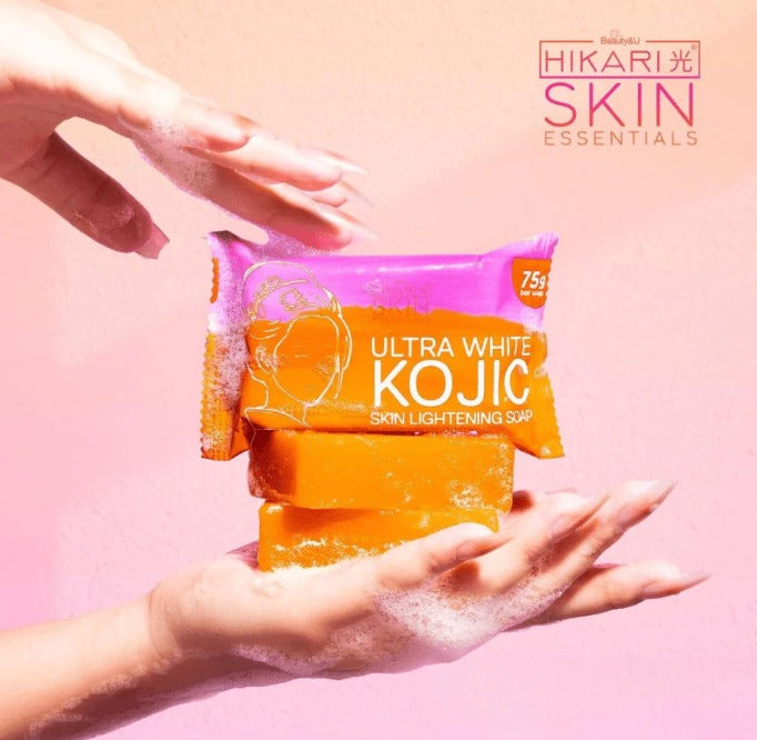 Ultra White Kojic soap with packaging held by hands against a pink background, featuring Hikari Skin Essentials branding.