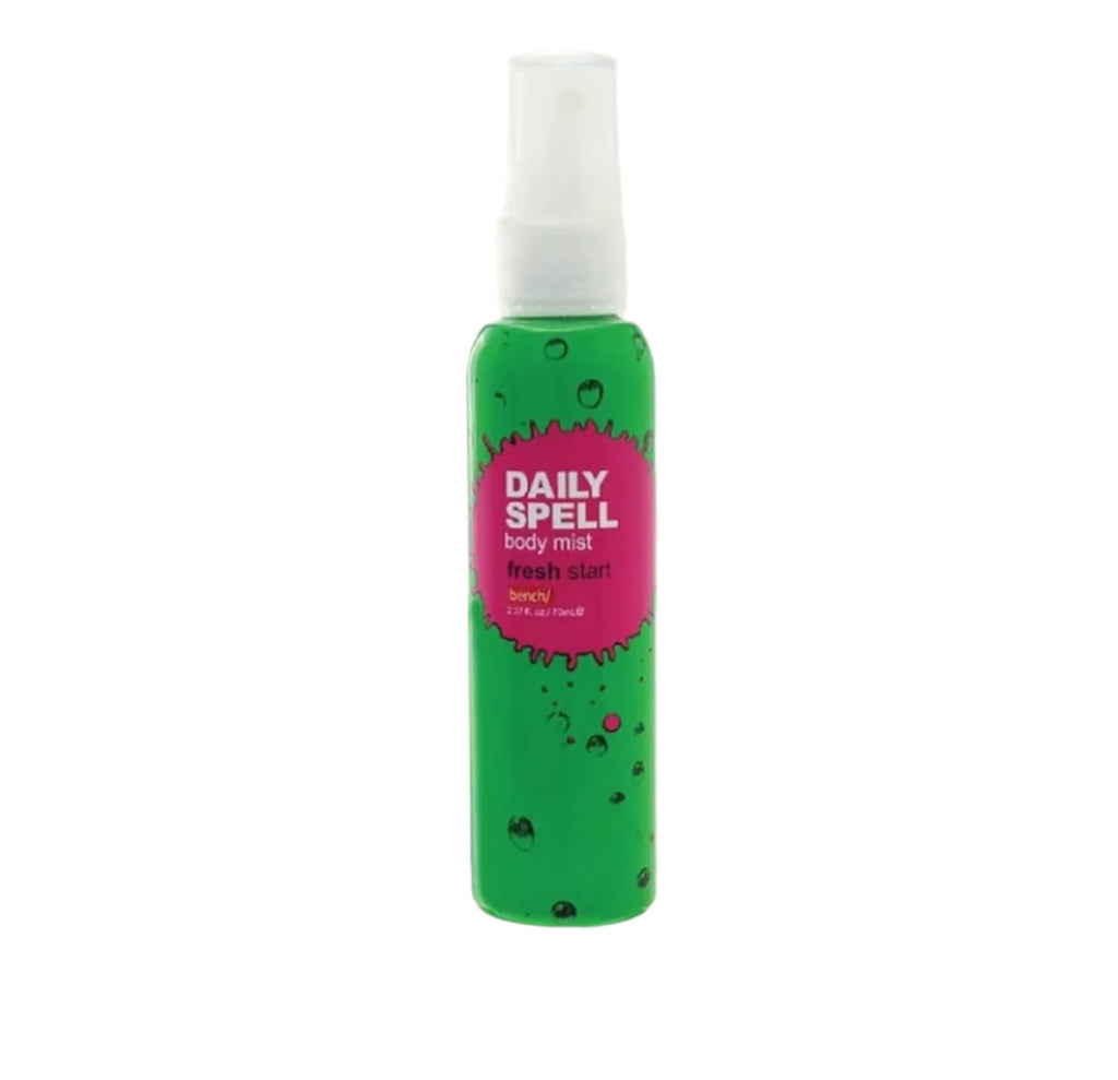 Green body mist bottle with pink label on a beige background, featuring the Bench brand.