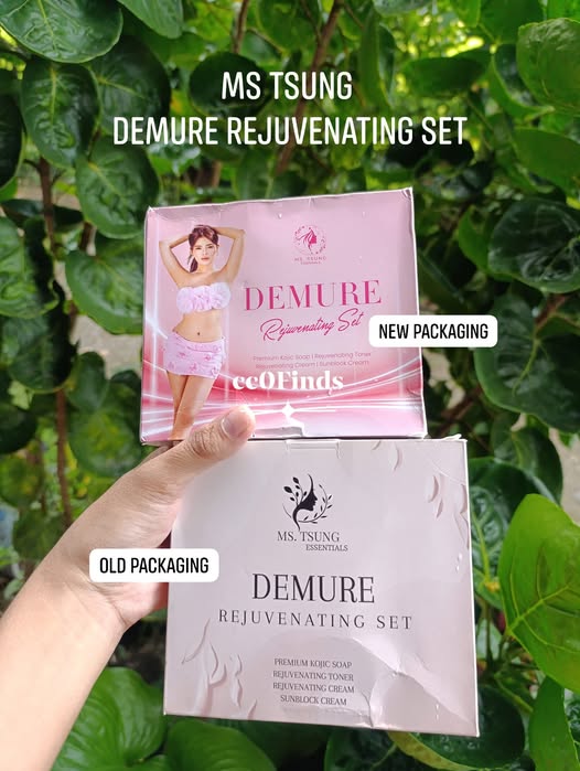 Hand holding two Demure Rejuvenating Set packages, one old packaging and one new packaging, against a green leafy background.