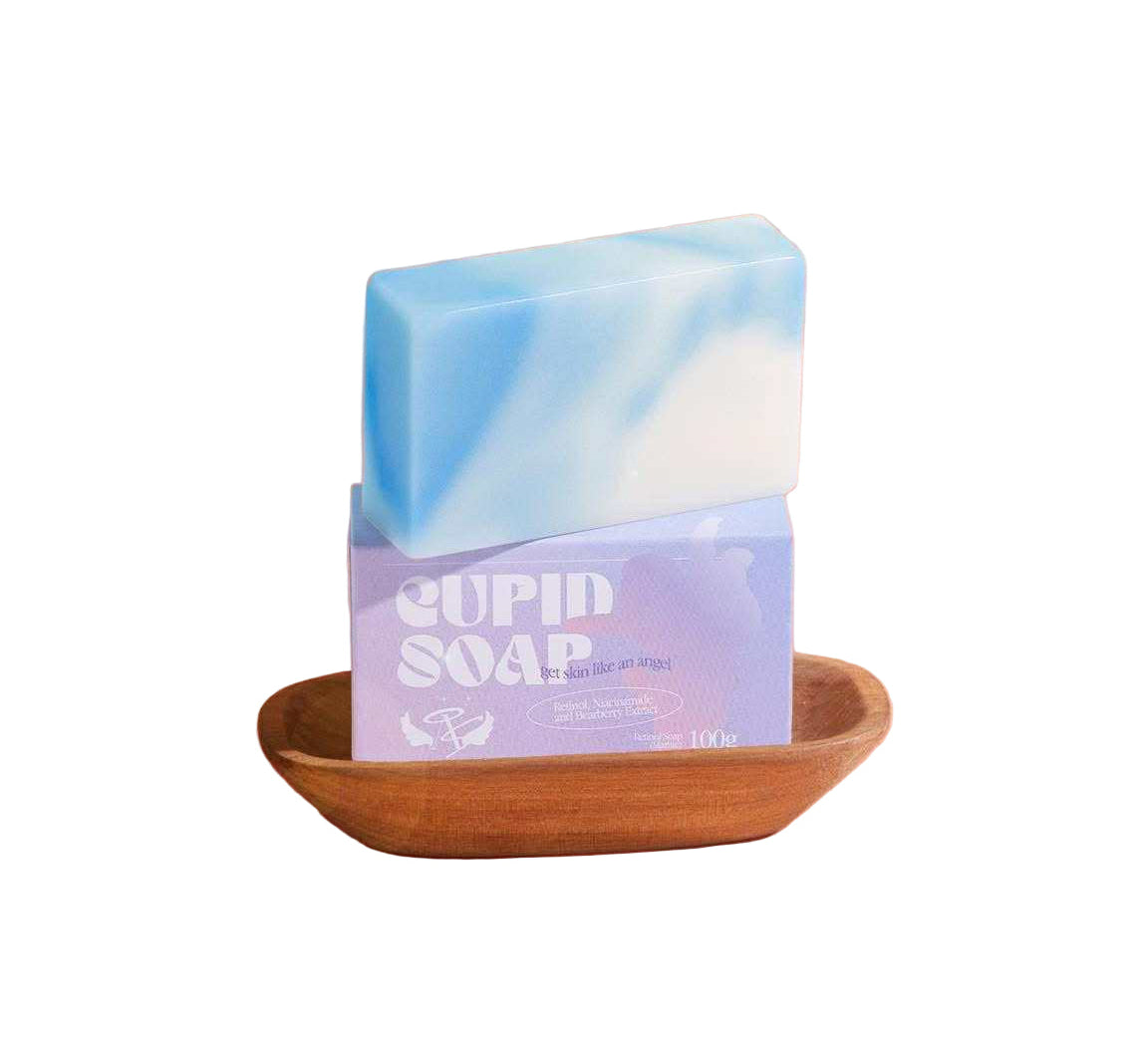 Blue and white soap bar with 'Jupin Soap' packaging on a wooden dish against a white background