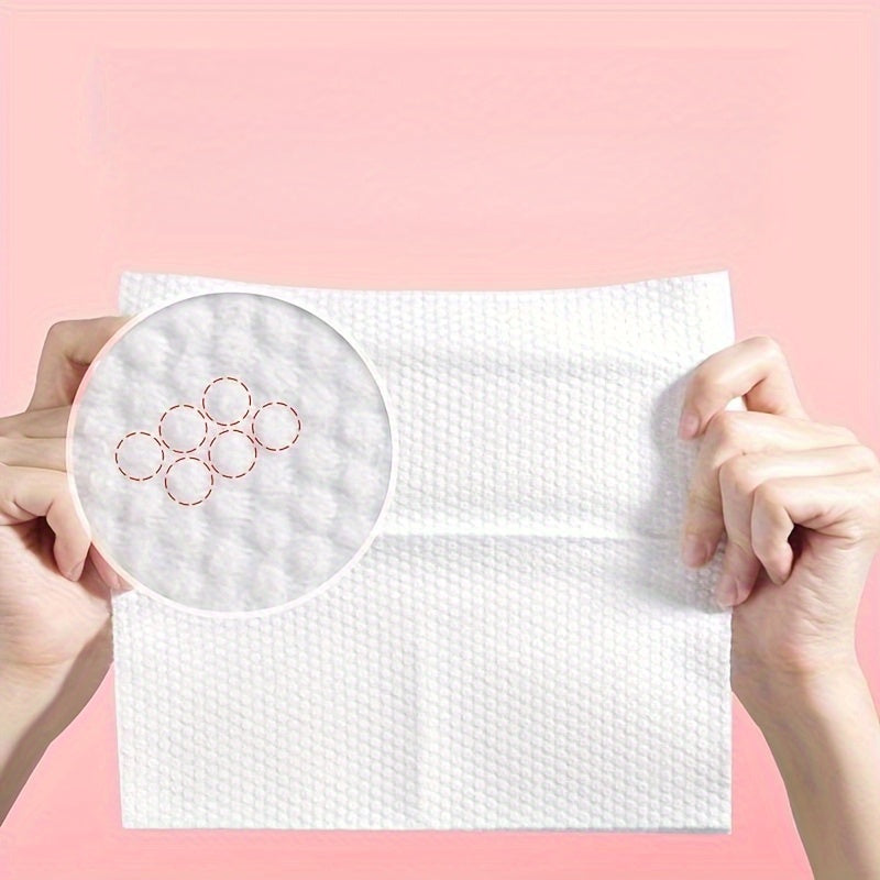 White paper towel with circular cutouts held by hands against a pink background