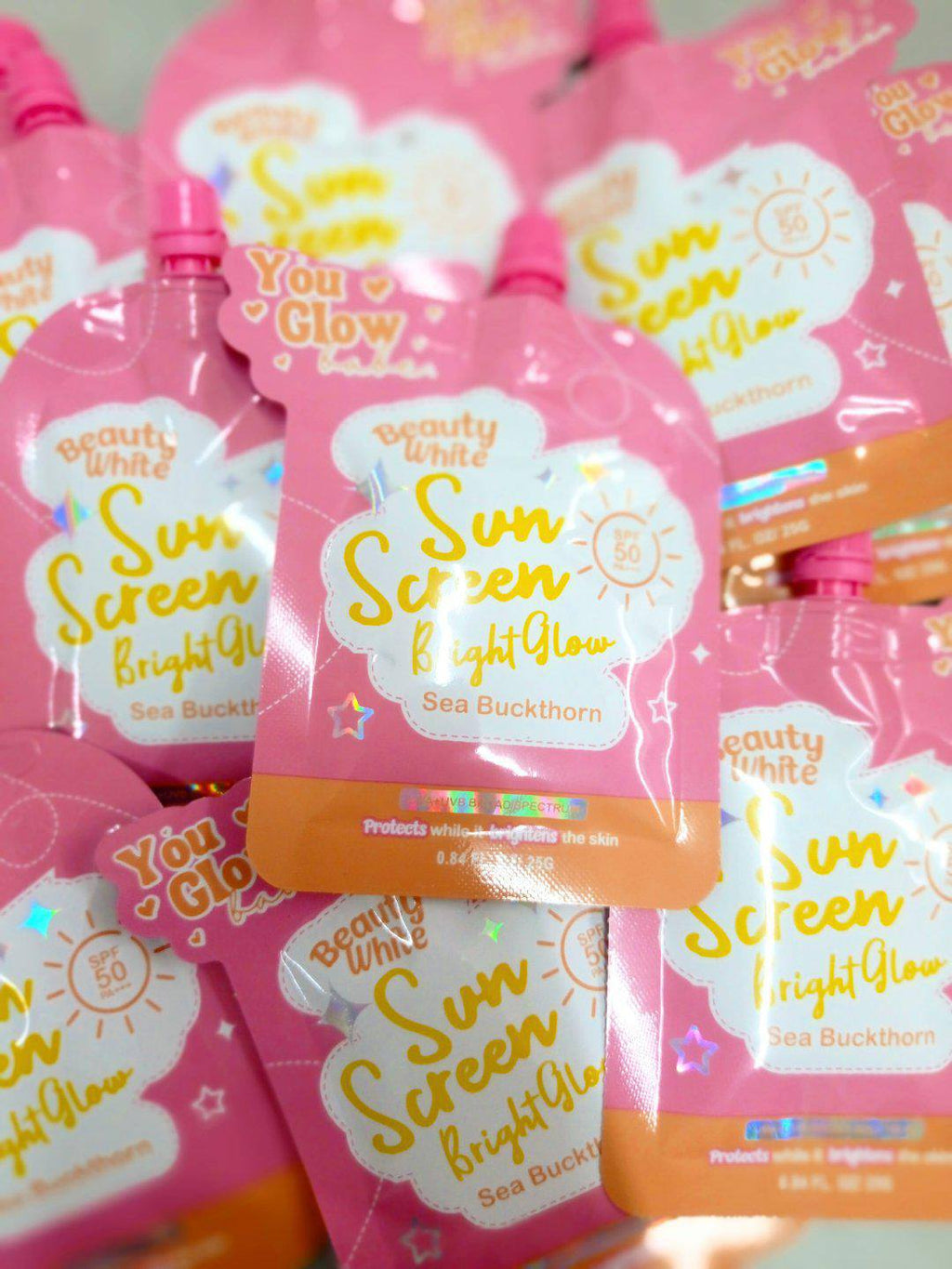 Multiple bottles of 'Sun Screen Bright Glow' with visible branding on a light background.