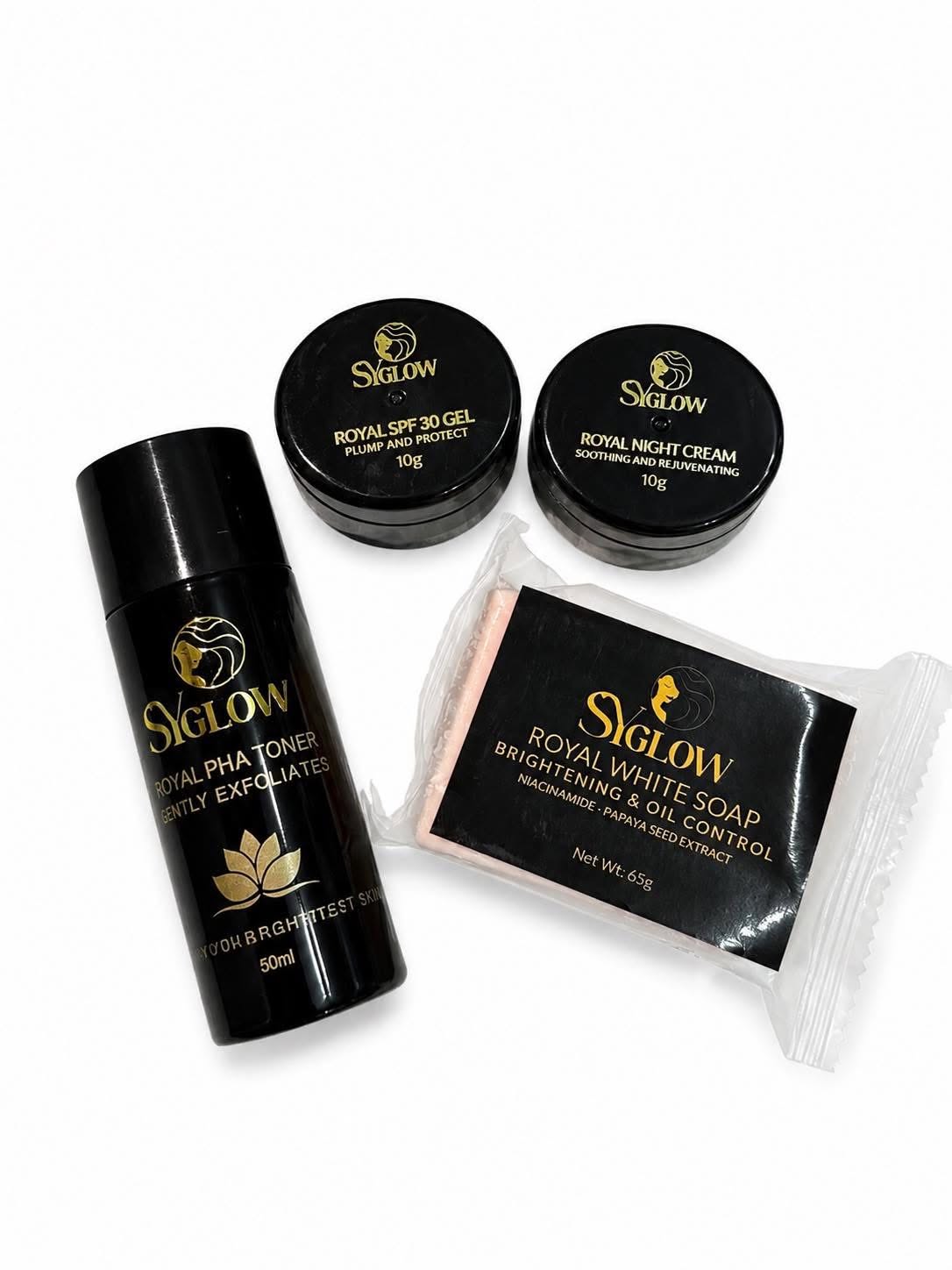 A skincare set from Siglow on a white background, including a black Royal Pha Toner bottle, two black jars of Royal SPF 30 Gel and Royal Night Cream, and a packaged black Royal White Soap block.
