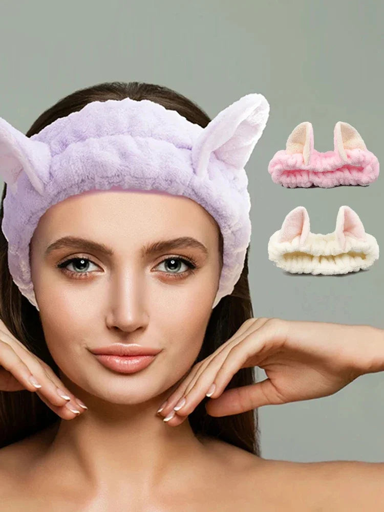 Woman wearing a purple eye mask with cat ears, with additional masks in the background.