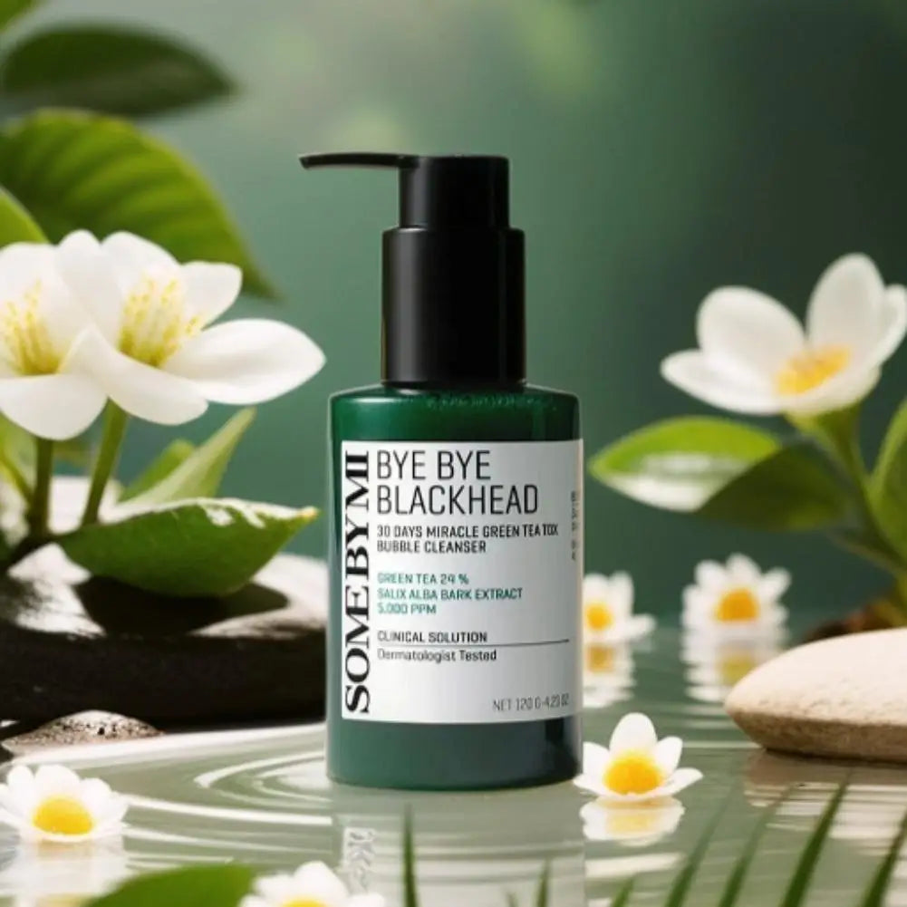 Skincare bottle labeled 'Bye Bye Blackhead' with green tea leaves and flowers in the background