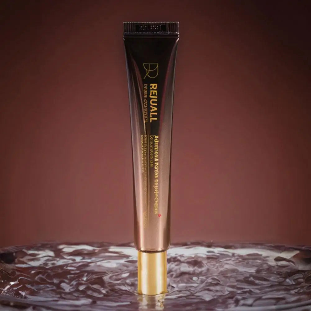 REUVALL skincare serum tube on a marbled surface with a brown background