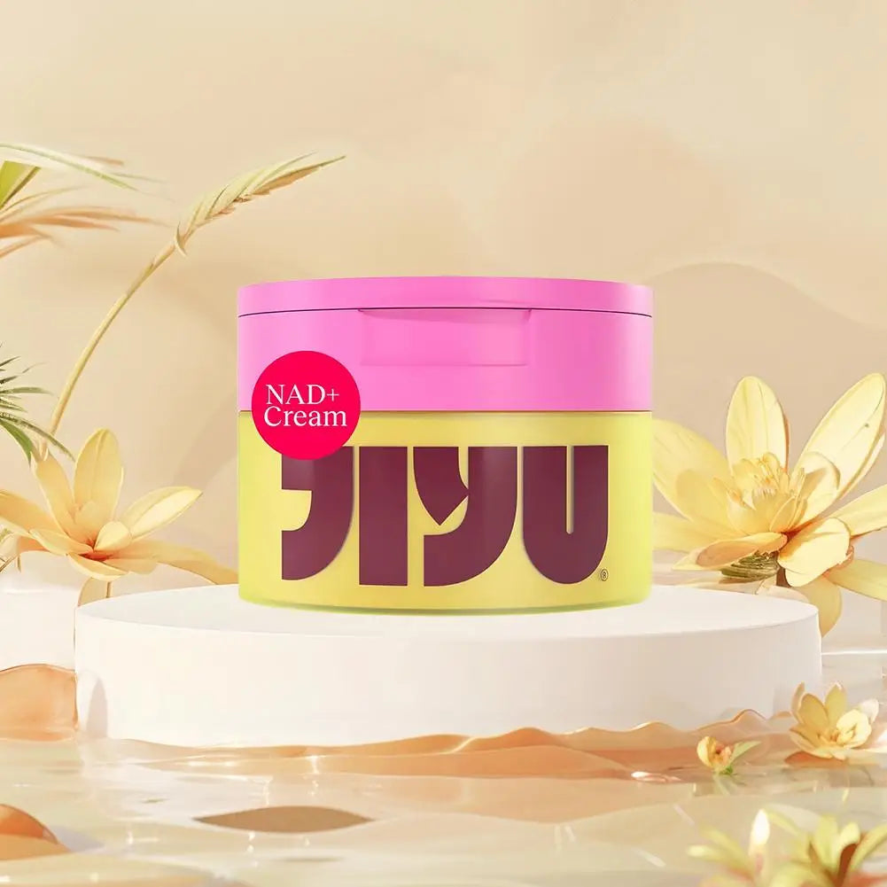 Jar of NAD+ Cream with pink lid and yellow body on a white platform with floral decorations.