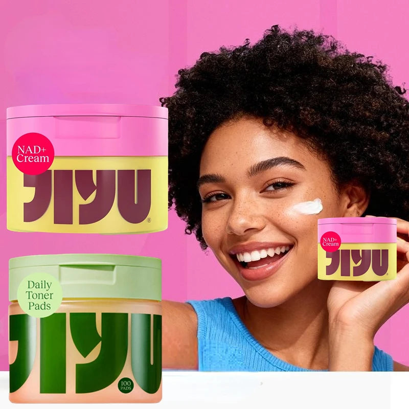 Woman applying NAD+ Cream to her face with NAD+ Cream products displayed on a pink background