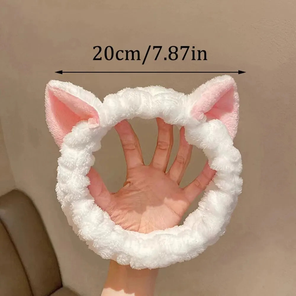 White fluffy headband with pink cat ears held against a hand, showing measurement 20cm/7.87in.