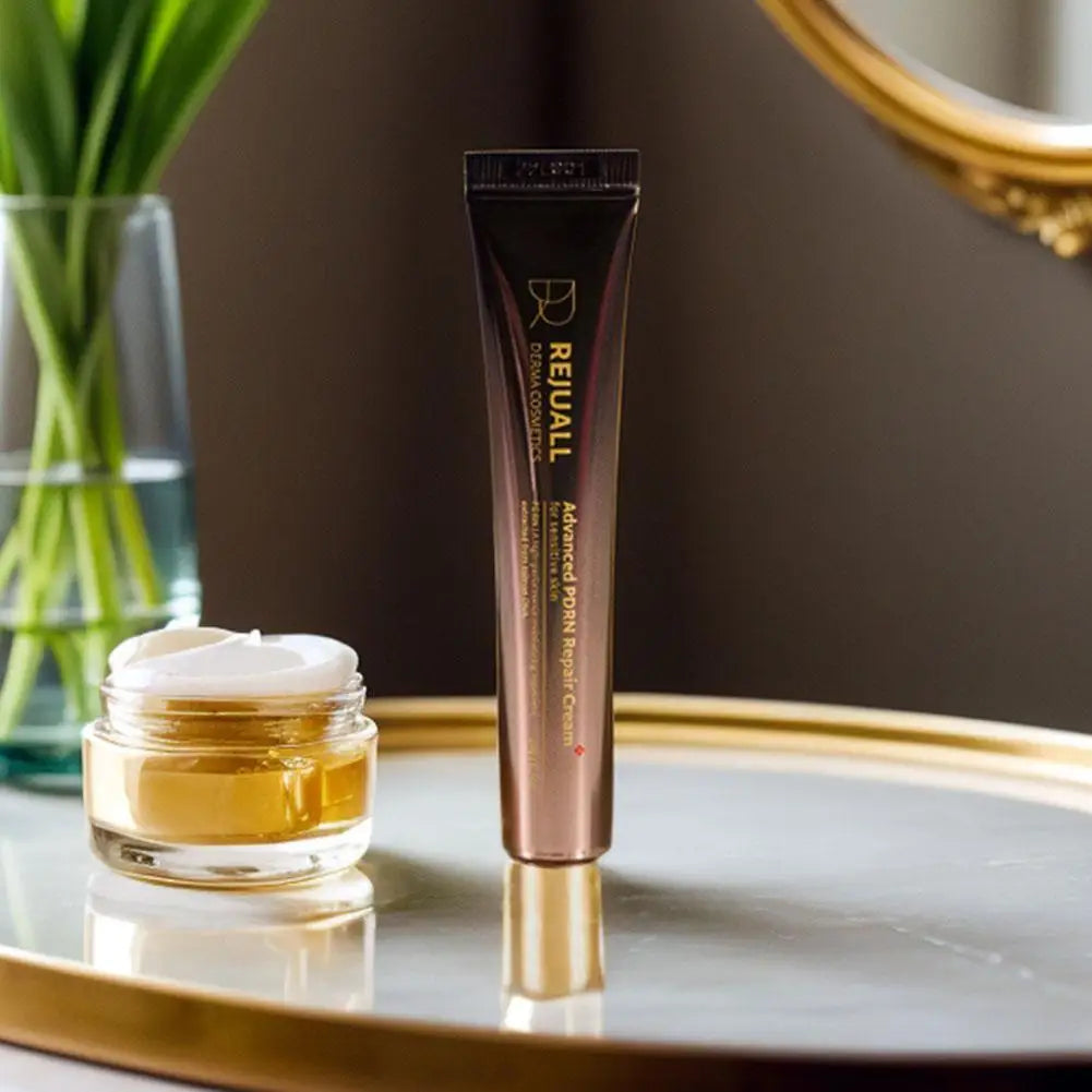 Cosmetic tube and jar on a reflective surface with a blurred background