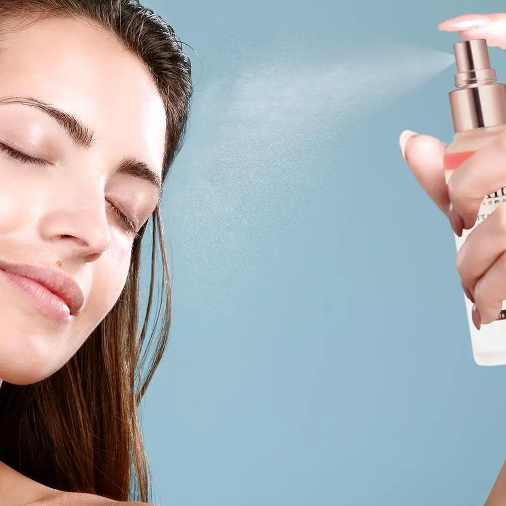 Woman applying a mist spray to her face against a light blue background