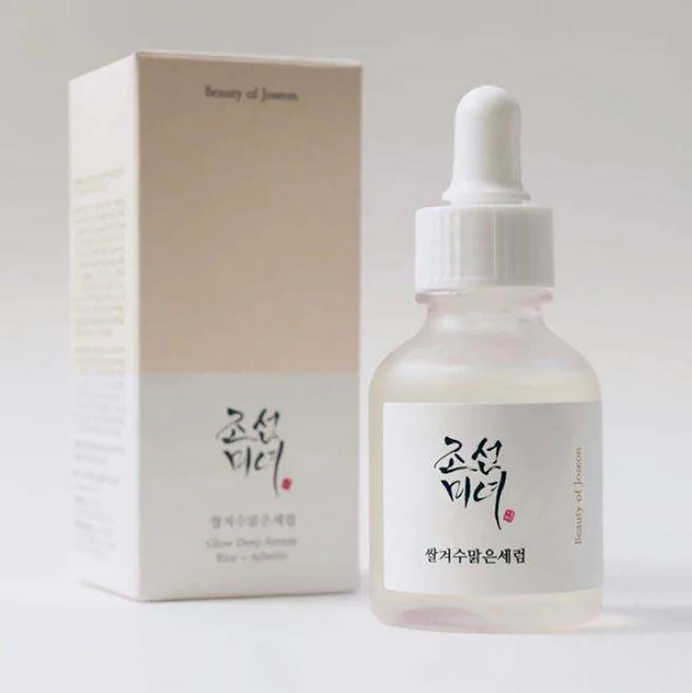 Skincare serum bottle with dropper and packaging on a light gray background