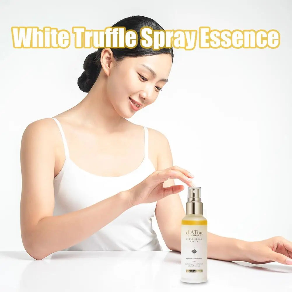 Woman holding a bottle of White Truffle Spray Essence with a plain background