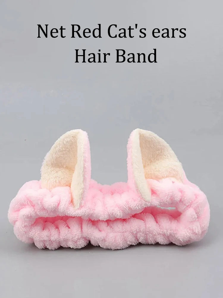 Pink hair band with cat ears on a gray background