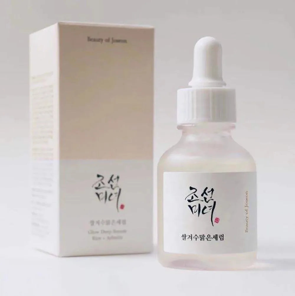 Skincare serum bottle with dropper and packaging on a light gray background