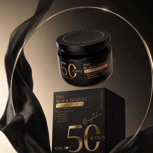 A black cosmetic jar labeled 'PRO BLACK GINSENG WHOLE BODY CREAM 50 ACIVES' sits above its matching black retail box, styled with flowing black fabric and a thin gold ring on a dark gradient background.