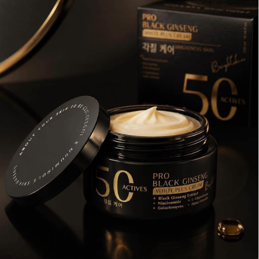 An open black jar of Pro Black Ginseng White Plus Cream with cream visible inside, shown beside its matching black box and a single capsule on a glossy black surface.