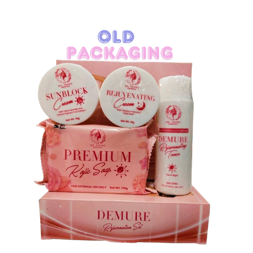 A skincare gift set featuring Demure products including Premium Kojic Soap, Sunblock Cream, and Rejuvenating Cream, arranged in front of their pink retail packaging boxes on a white background with 'OLD PACKAGING' text overlay.